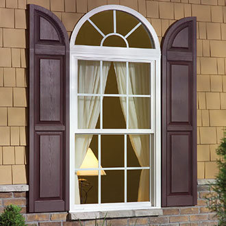 Alcoa shutters with an arch top installed on a house window.