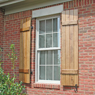 Wooden Stained Board and Batten Shutters on a Brick House